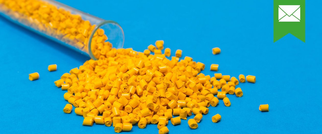 Kunststoff Gelbe Plastikpalletts rollen aus einem Reagenzglas auf blauem Untergrund