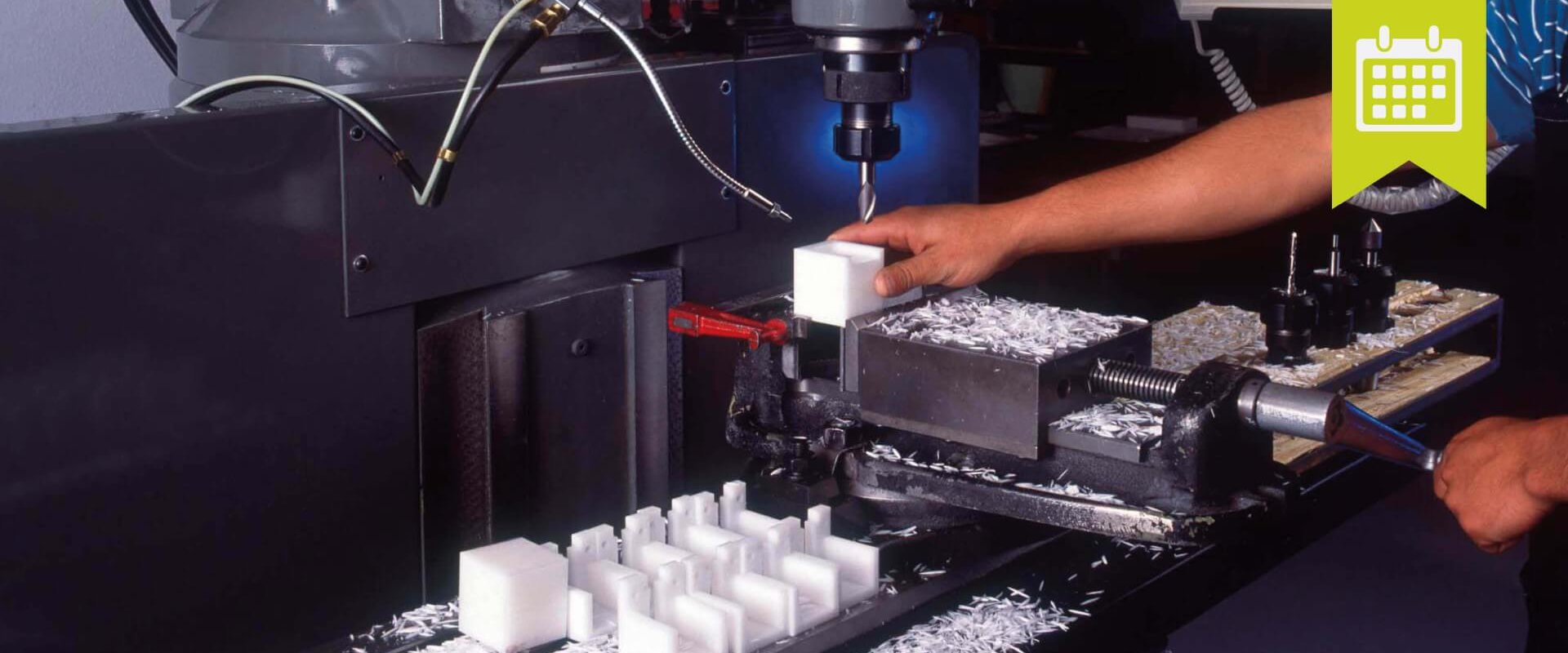 Kunststoff Ein Mann arbeitet an einer Maschine, die weiße Kunststoffwürfel herstellt.