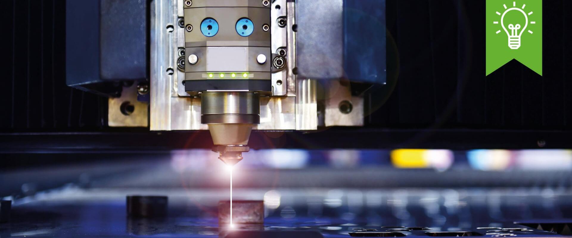 Upkino Eine Maschine schneidet Metall mit einem rotem Laser.