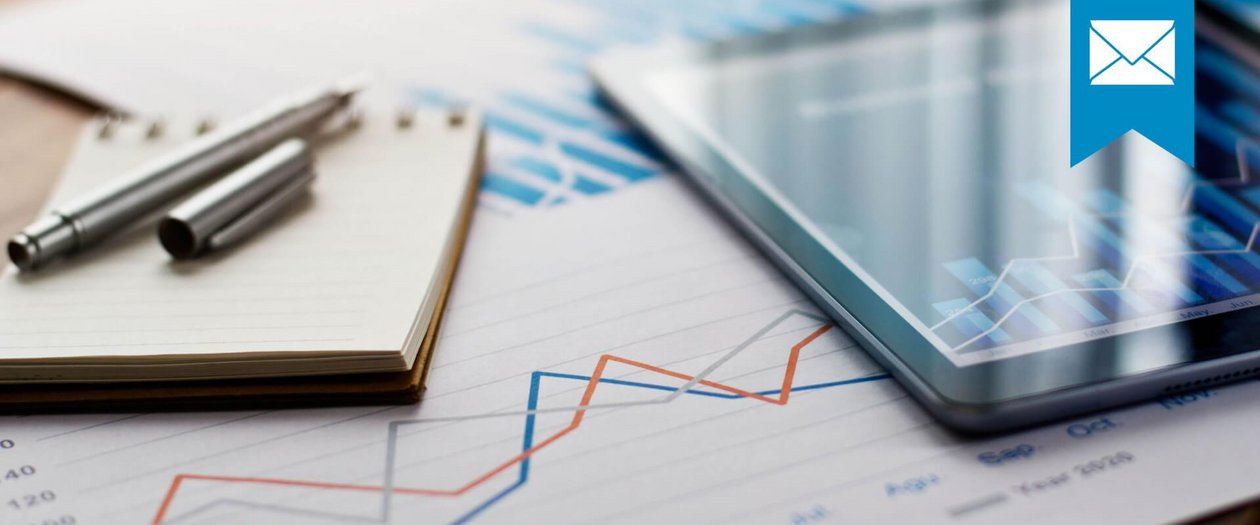 Monitoringbericht Notizblock, Tablett mit Balkendiagramm und ein Ausdruck mit Liniendiagramm sollen die Entwicklung verschiedener Kennzahlen darstellen